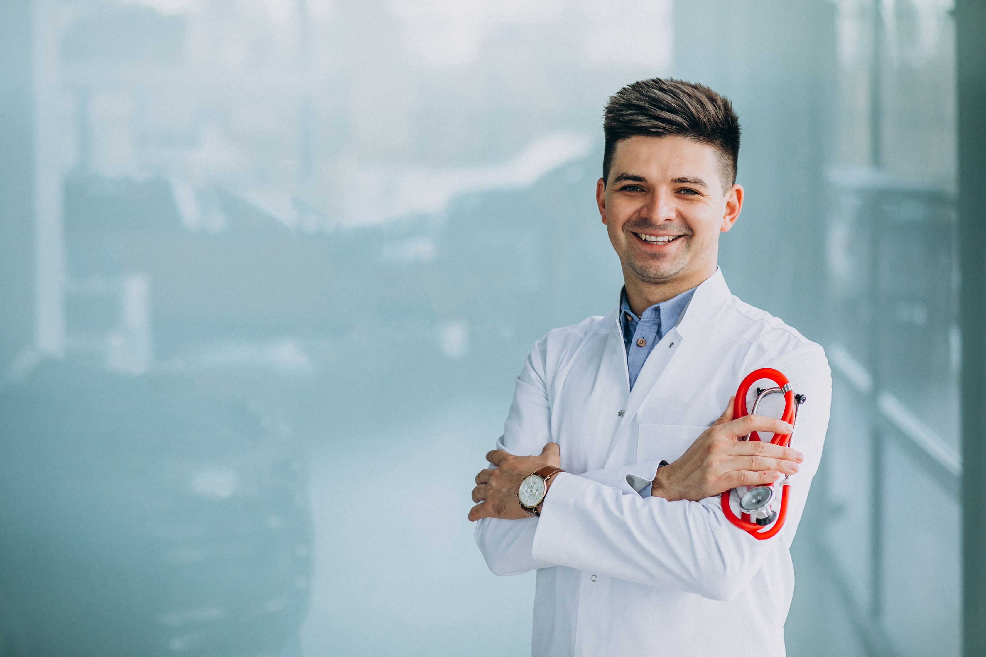 Young handsome physician in a medical robe with stethoscope